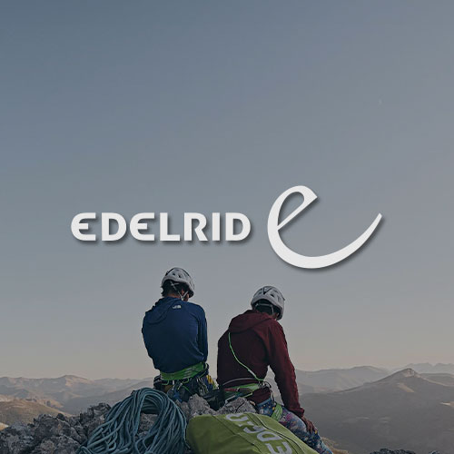 Zwei Kletterer sitzen auf der Spitze eines Berges. Im Hintergrund die Landschaft mit Bergen. Mittig im Bild wird das Edelrid Logo dargestellt.