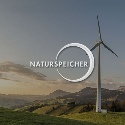 Landschaft mit Wiesen und Wäldern und einem Windrad. Mittig im Bild wird das Naturspeicher Logo dargestellt.