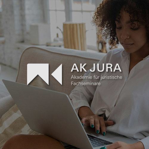 Frau sitzt auf einem Sofa und arbeitet an einem Laptop. Mittig im Bild wird das AK Jura Logo dargestellt.